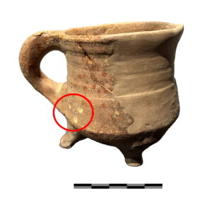 Grape of schenkbeker uit 1450-1575 met de drie ronde puntjes aan de buitenkant (eigendomskenmerk) omcirkeld.