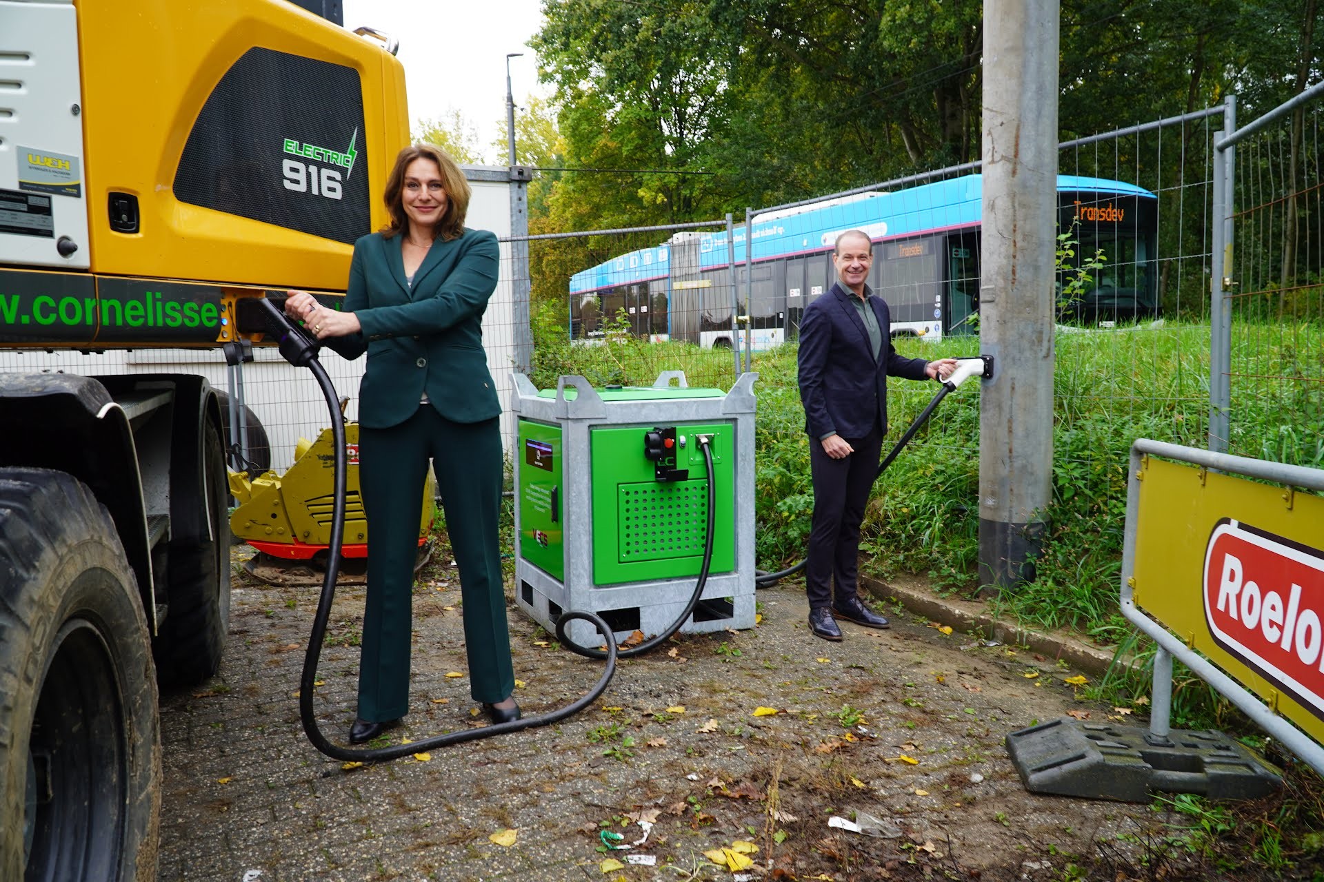 Wethouder Duurzame mobiliteit Nermina Kundić en Alexander ten Have van Transdev koppelen een elektrische bouwkraan aan het trolleynet.